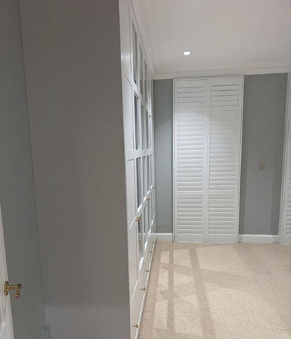 Moisture-resistant plantation shutters fitted above a bath