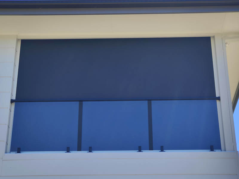 Navy zip track alfresco blind part way down over a balcony opening